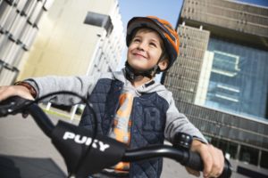 Enfant avec un casque souriant sur son vélo