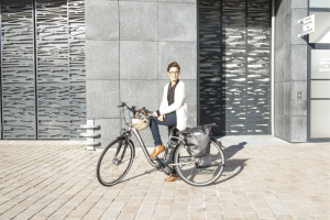 Femme à l'arrêt avec un vélo électrique