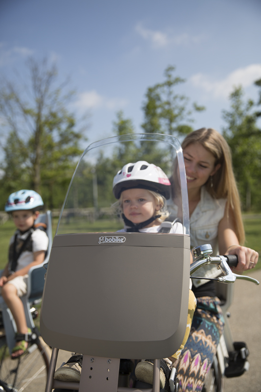 Maman avec sa petite fille sur un siège bébé vélo avant