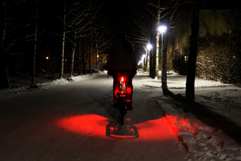 vélo qui s'éloigne de nuit et dans la neige en ville