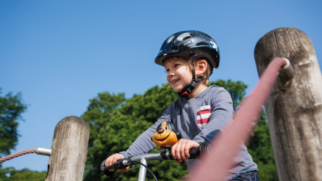 Enfant souriant sur sa draisienne