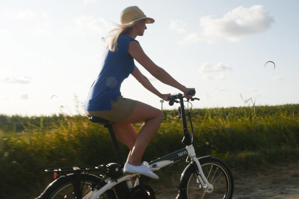 Femme sur un vélo électrique pliant à la campagne