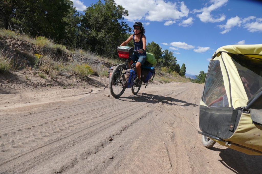 Famille à vélo roulant dans le sable