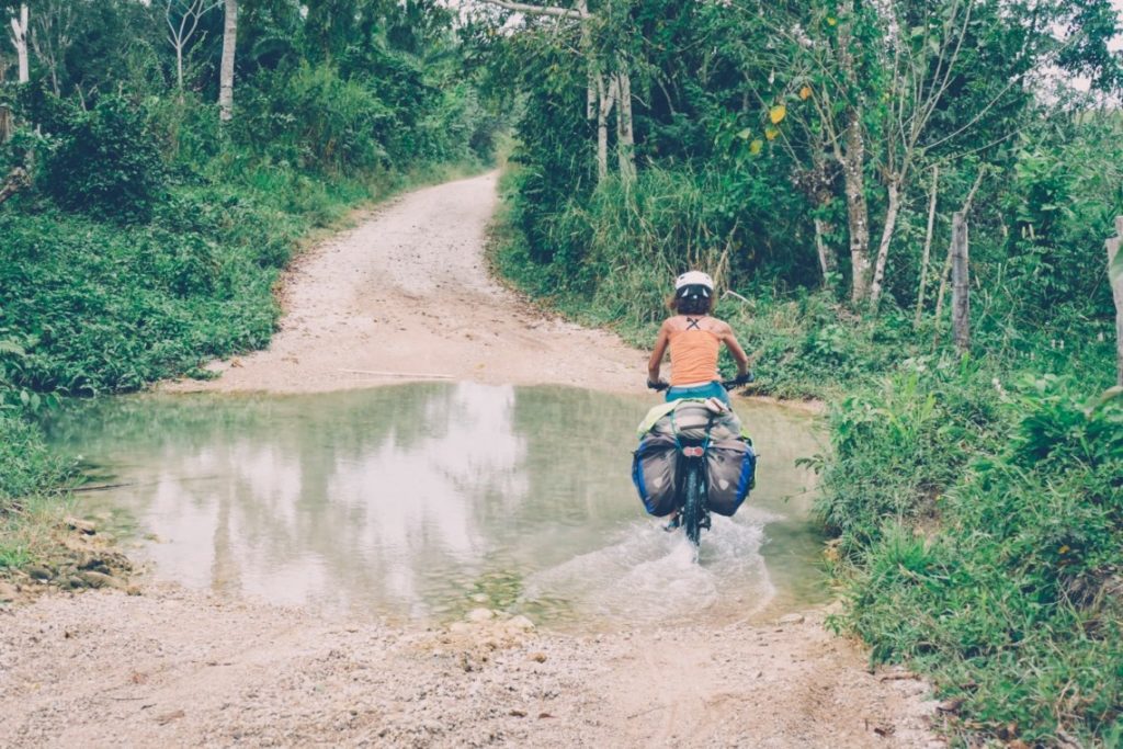 Femme à vélo traversant un gué