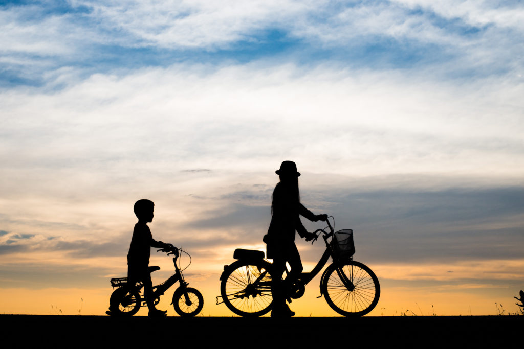 Coucher de soleil avec une femme et son fils à vélo