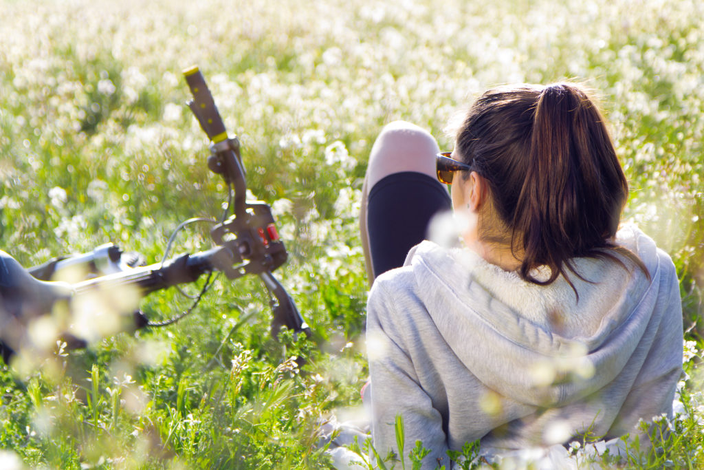 Femme allongé dans l'herbe près de son vélo