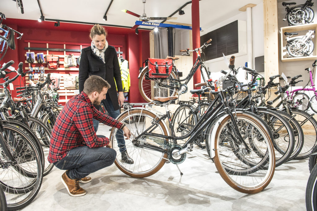 Vélociste qui répare le vélo d'une cliente cycliste