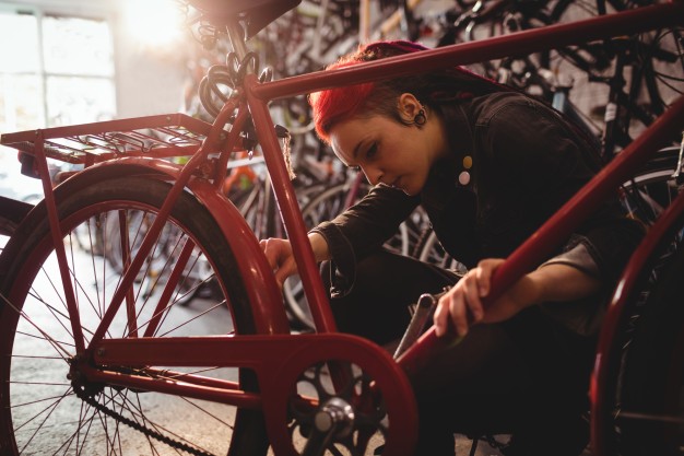 Mécanicienne en train de réparer un vélo de ville