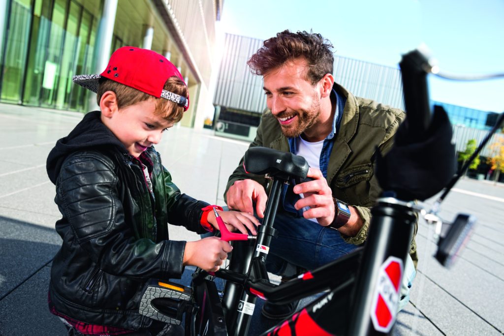 Père et son fils en train de régler la selle du vélo enfant