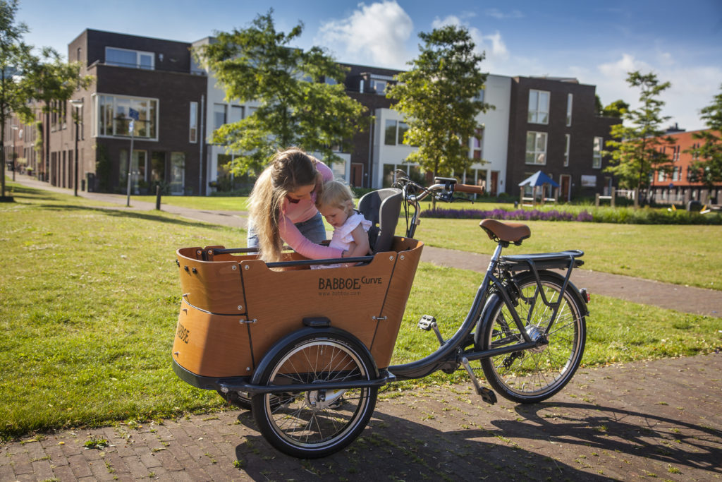 Mère attachant son enfant dans un triporteur