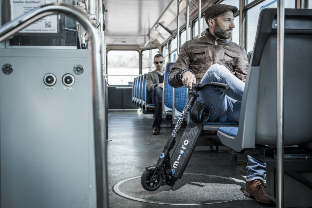 Homme dans le bus avec une trottinette electrique pliee