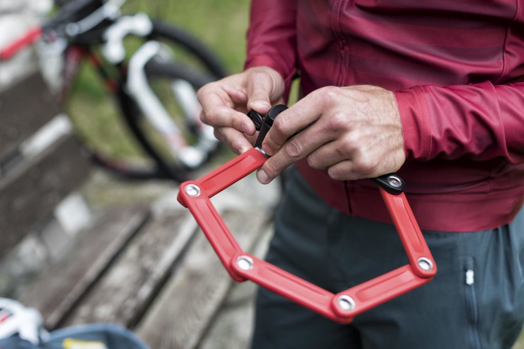 Cycliste qui déplie son antivol pour cadenasser son vélo