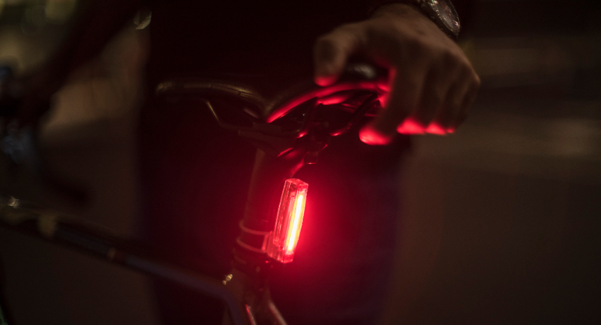 Gros plan sur phare arrière rouge fixé sur la tige de selle d'un vélo