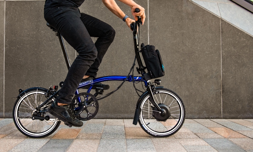 Người đi xe đạp đạp trên một chiếc xe đạp điện gấp Brompton