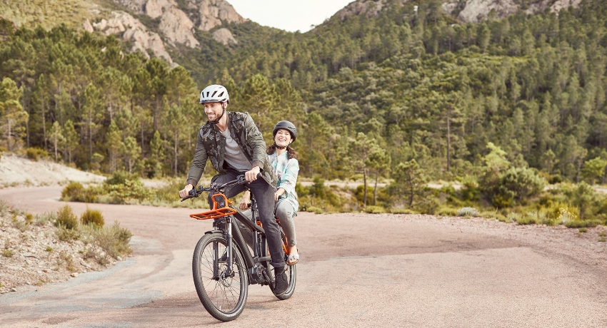 Couple sur un vélo cargo à la montagne
