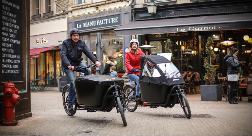 Deux cyclistes sur des vélos cargo en ville