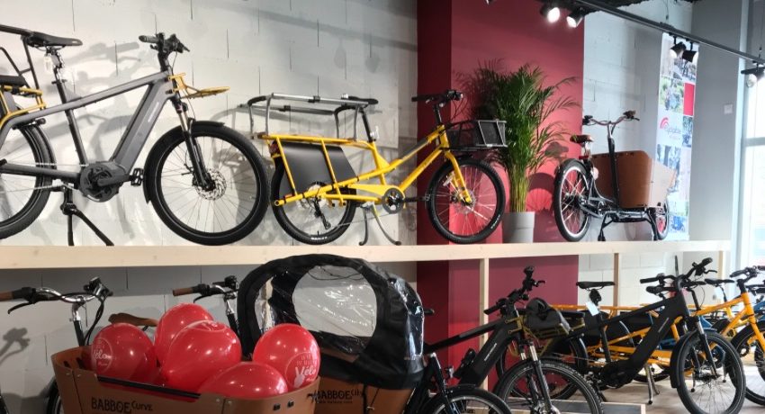 Des cargos et des vélos à assistance électrique sur un présentoir à deux niveaux au magasin de Cyclable Castelnau