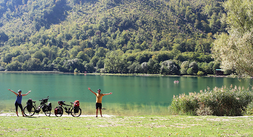 Pierre et Morgane aux côtés de leurs vélo de voyage dans un paysage de lac de montagne