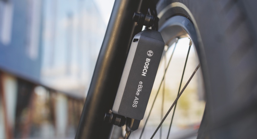 Zoom sur le dispositif ABS miniature de Bosch fixé sur la roue avant d'un vélo