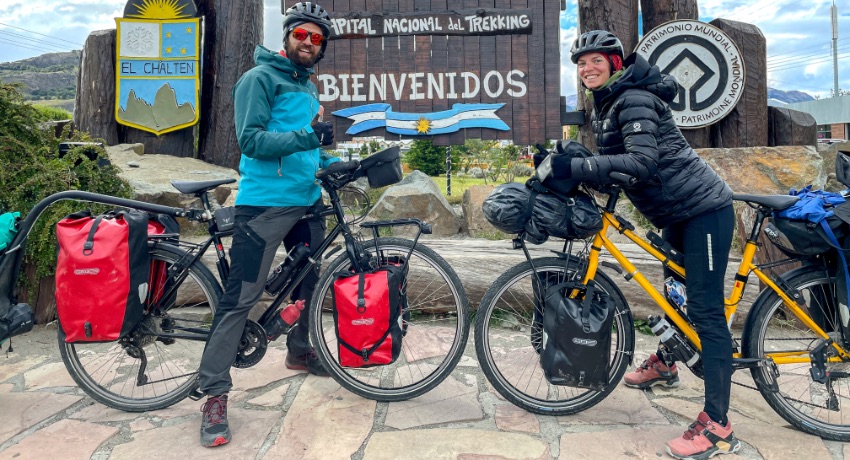 Clémence et Thomas posent sur leurs vélos de voyage à El-Chalten, en Argentine.