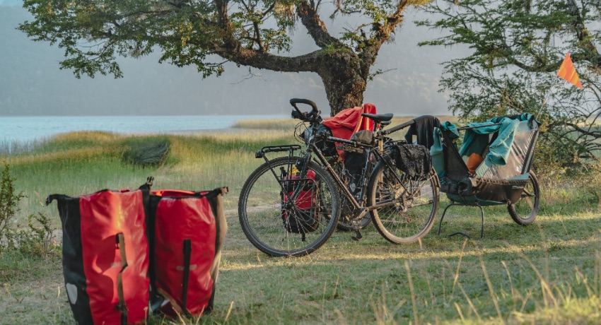 Les vélos de Clémence et Thomas, la remorque de Zoé et les sacoches familiales installés au bord d'un lac.