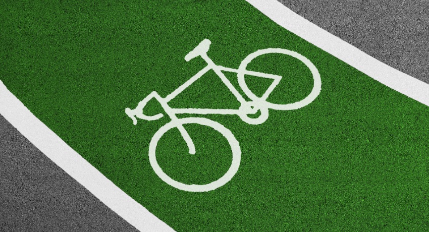 Une piste cyclable verte avec un pictogramme vélo blanc. 