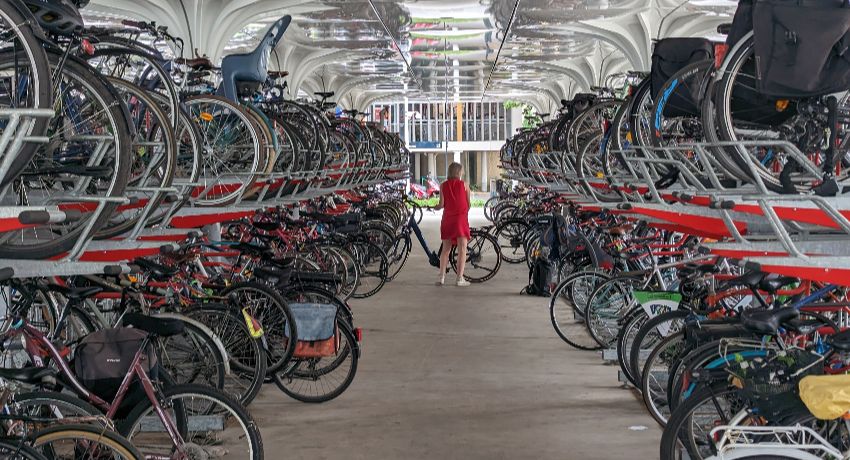 Des dizaines de vélos superposés sur deux rangées dans un parking vélo sécurisé de la gare de Nantes.
