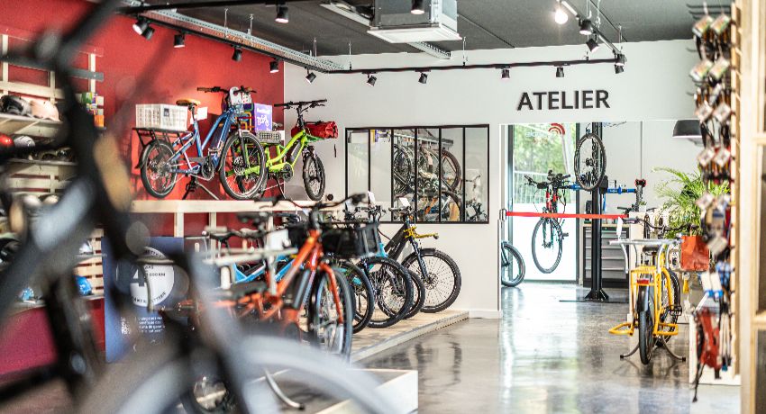 Des vélos longtails et des VAE dans le showroom de Cyclable Meylan avec l'atelier en arrière plan.
