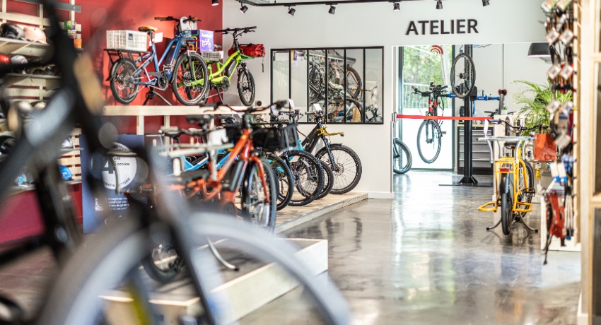 Des vélos longtails et des VAE dans le showroom de Cyclable Meylan avec l'atelier en arrière plan.