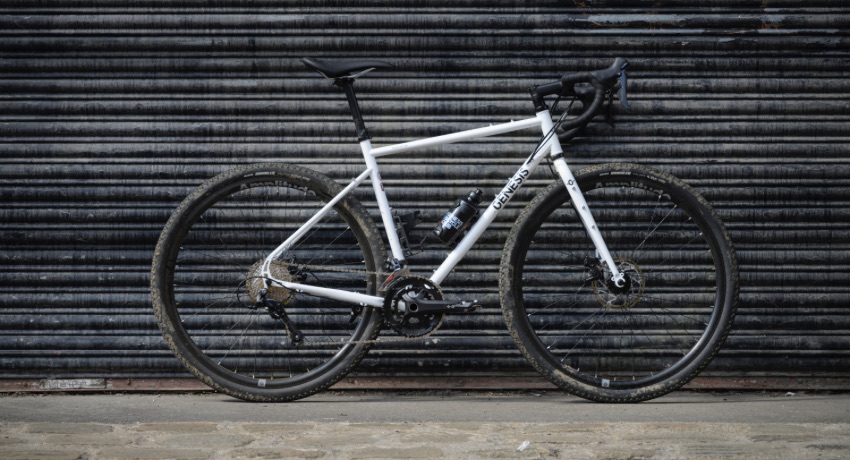 Le nouveau Genesis Croix de Fer 10, maculé de boue, appuyé contre un rideau de fer.