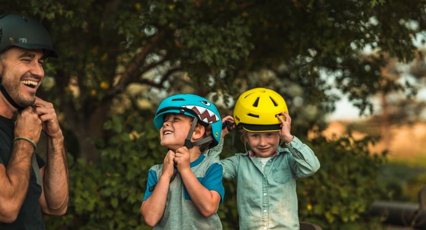Deux jeunes garçons en train de coiffer leur casque Bern dans la nature.